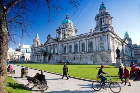 Belfast City Hall with visitors and cyclists in Donegall Square, Northern Ireland