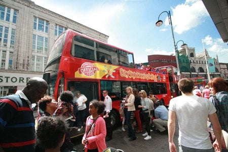 Belfast City Sightseeing tour passengers getting off the tour bus in Belfast city centre