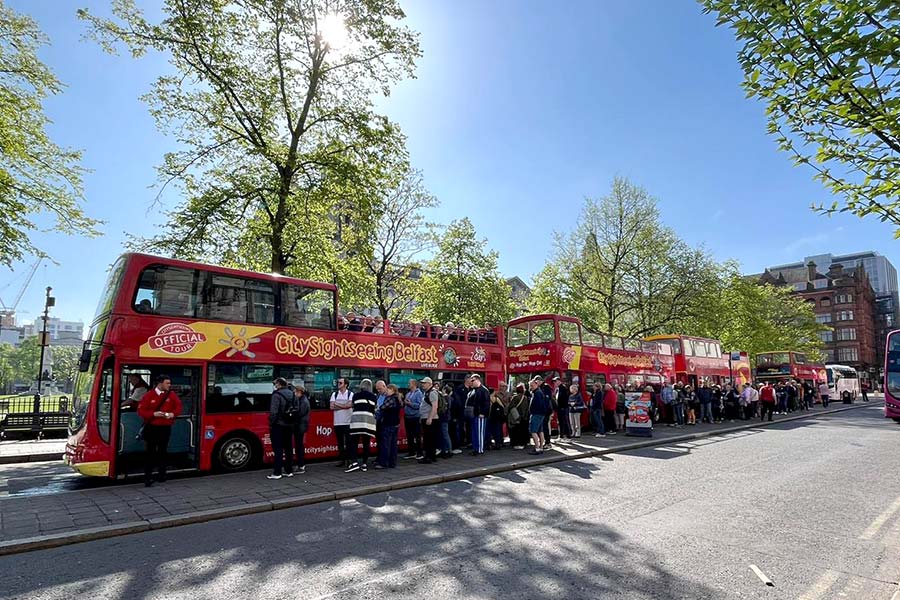 Passengers waiting to board the Belfast City Sightseeing bus at stop 1