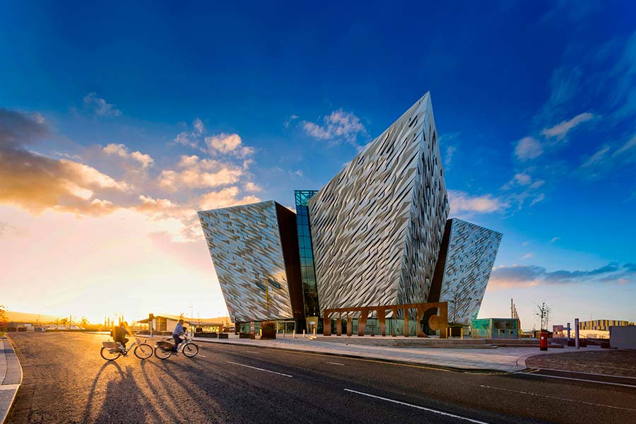 Titanic Belfast building at sunset with cyclists in the Titanic Quarter, Northern Ireland